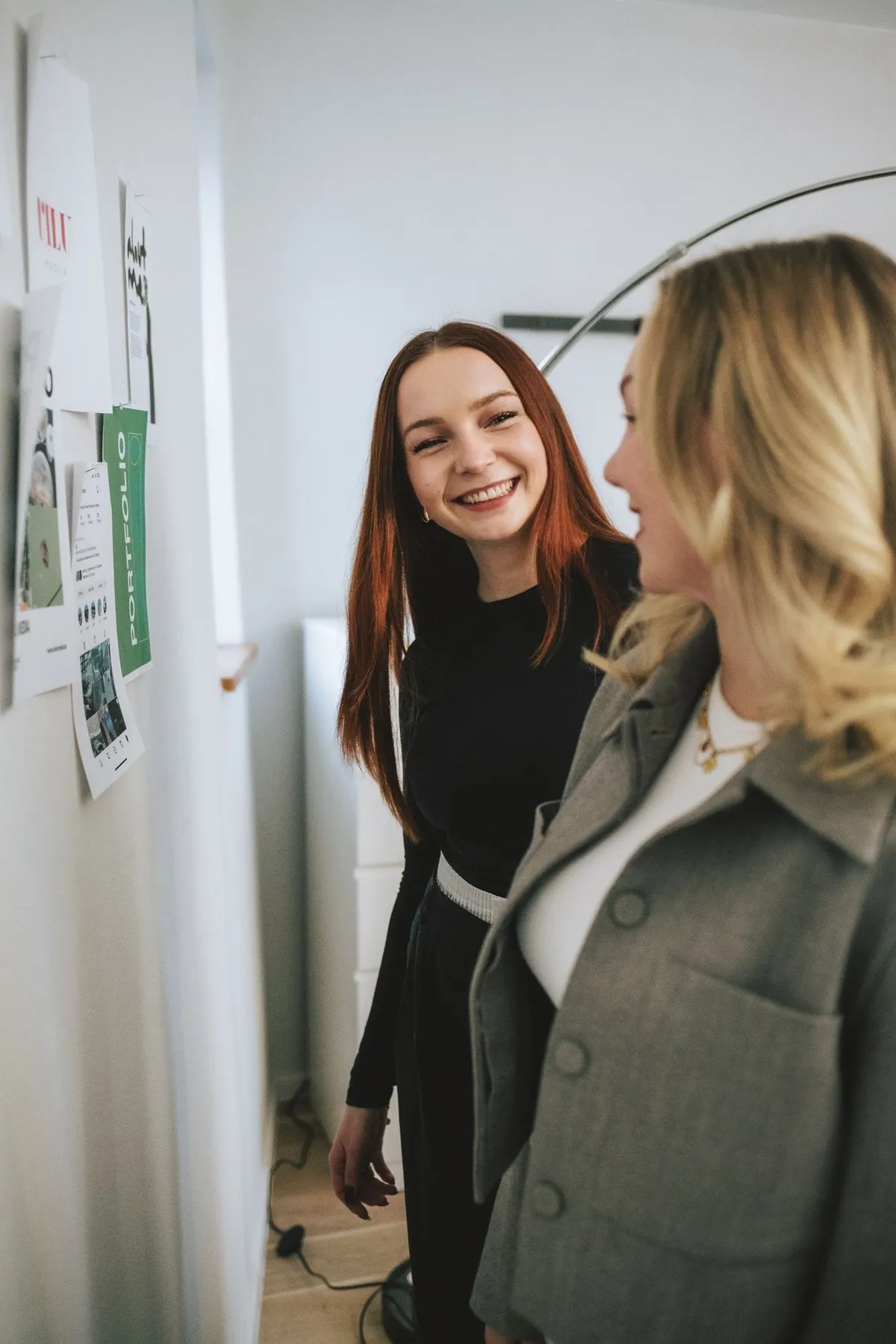 Luise und Violetta Wißmann lachen vor einer Wand mit Entwürfen und Moodboards